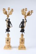 A PAIR OF BRONZE AND GILT BRONZE FOUR BRANCH, FIVE LIGHT, FIGURAL CANDELABRA. 72cms high.