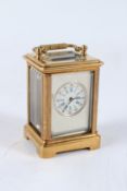 A MINIATURE BRASS SILVER FACED CARRIAGE CLOCK. 6cms high.