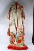 A GOOD 20TH CENTURY JAPANESE KIMONO, cream silk embroidered allover with flowers and foliage. 190cms