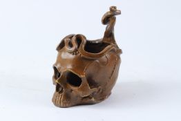 A BRONZE BOWL, modelled as a snake entwined skull. 18cms high.