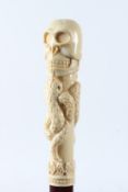 A WALKING STICK WITH SKULL AND SNAKES HANDLE. 93cms long.