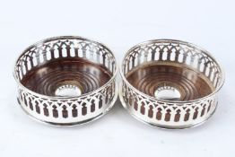 A PAIR OF PLATED WINE COASTERS with turned wood bases.