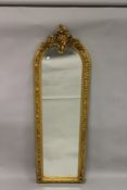 A TALL, NARROW GILTWOOD MIRROR, with floral and pierced shell shape cresting. 6ft 5ins high x 2ft