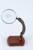 A MAGNIFYING GLASS ON ADJUSTABLE STAND. 16cms high.