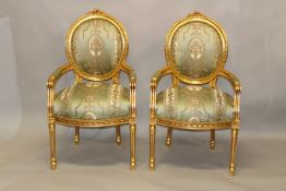 A PAIR OF FRENCH STYLE GILTWOOD ARMCHAIRS, upholstered with a classical style green ground fabric