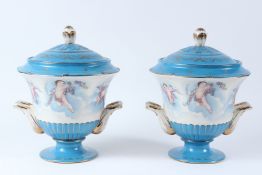 A PAIR OF SEVRES STYLE PORCELAIN TWIN HANDLED VASE AND COVERS, decorated with cherubs. 29cms high.