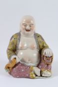 A GOOD PORCELAIN FIGURE, THE LAUGHING BUDDHA, with yellow and pink robe, holding a string of