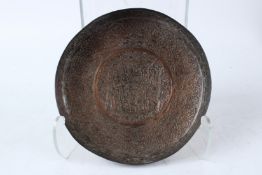A 19TH CENTURY OR EARLIER ENGRAVED ISLAMIC COPPER DISH with fine calligraphy. 24cms diameter.
