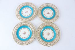 A SET OF FOUR MINTON PLATES, with pierced borders, decorated with floral swags and an armorial to