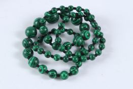 A LONG STRING OF MALACHITE BEADS. 60cms long.
