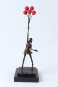 AFTER BANKSY. A bronze figure holding a bunch of red balloons, on a square marble base. 45cms high.