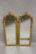 A PAIR OF NARROW GILTWOOD ARCH TOP MIRRORS, with legwork crestings. 5ft 0ins high x 2ft 0ins wide.
