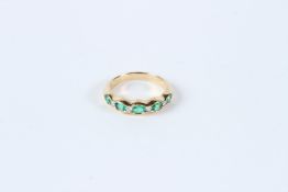 AN 18CT YELLOW GOLD, FINE EMERALD AND DIAMOND HALF HOOP RING.