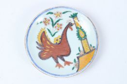 A SMALL TURKISH KUTAHYA CERAMIC DISH with a bird. 14cms diameter.