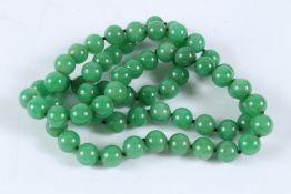 A LONG STRING OF JADE BEADS. 80cms long.