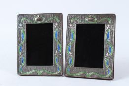 A PAIR OF SILVER AND ENAMEL ART NOUVEAU STYLE PHOTOGRAPH FRAMES. 20cms high.