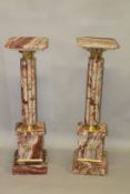 A PAIR OF VARIEGATED ROUGE MARBLE AND ORMOLU MOUNTED PEDESTAL COLUMNS. 3ft 4ins high x 11ins wide.