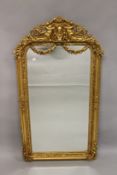 A GILTWOOD PIER MIRROR with shield and cherub cresting. 5ft 2ins high x 2ft 10ins wide.