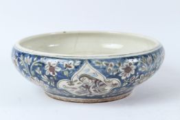 A GLAZED QAJAR BOWL painted with figures in a landscape. 26cms diameter.