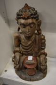 A painted carved wood figure of a seated Eastern Deity.