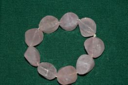 A chunky rose quartz bracelet.