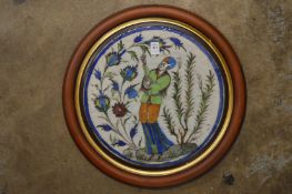 A good Persian Qajar circular ceramic plaque depicting a muscian, framed.