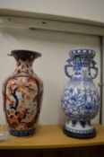 A large Imari vase (faults) together with a Chinese blue and white twin handled vase on stand.