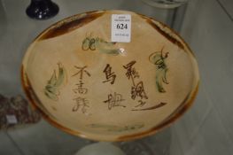 A Chinese pottery bowl with calligraphy decoration.