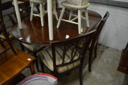 A modern mahogany drop-leaf dining table with four chairs.