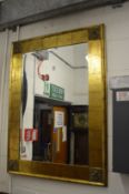 A decorative gilt framed rectangular wall mirror.