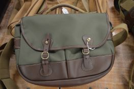 A green canvas and leather shoulder bag.