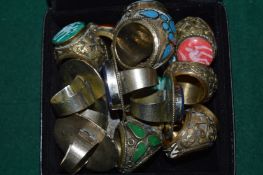 A collection of Eastern white metal and hard stone rings.