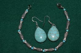A pair of turquoise earrings and a turquoise and silver bracelet.