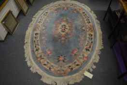 A Chinese oval shaped rug, blue ground with floral decoration, 188cm x 126cm.