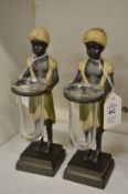 A pair of painted cast bronze figures holding glass phials.
