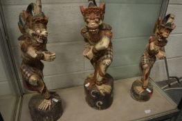 Three large Eastern carved wood and painted figures.