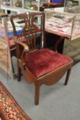 A George III mahogany elbow chair with crimson upholstered drop-in seat.