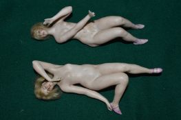 Two porcelain figures of reclining female nudes, one repaired.