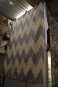 A woollen rug with zigzag design, 227cm x 175cm.