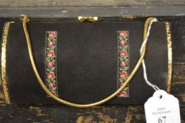 A black and gilt clutch bag.