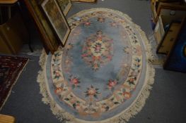 A Chinese oval shaped rug, blue ground with floral decoration, 188cm x 126cm.