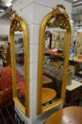 A pair of decorative gilt framed arch topped mirrors.
