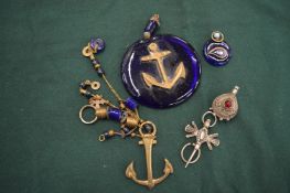An unusual glass and brass pendant with anchor and other items.