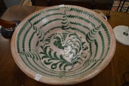 A large terracotta bowl with slip glazed decoration.