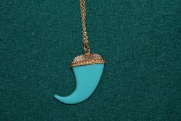A tooth shaped pendant with gilt metal chain.