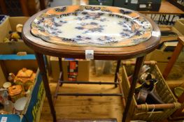 A faux bamboo stand containing an ironstone charger.