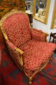 A pair of gilt framed crimson upholstered armchairs in the French style.