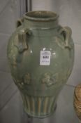 A large Chinese celadon glazed vase with four strap work handles.