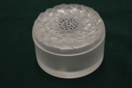 A Lalique frosted glass circular box and cover, the cover moulded as a flower.
