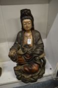 A carved and painted seated Chinese figure depicting Guan Yin.